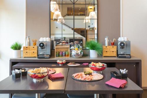 a table with plates of food on it at Mercure Grenoble Centre Porte des Alpes in Grenoble