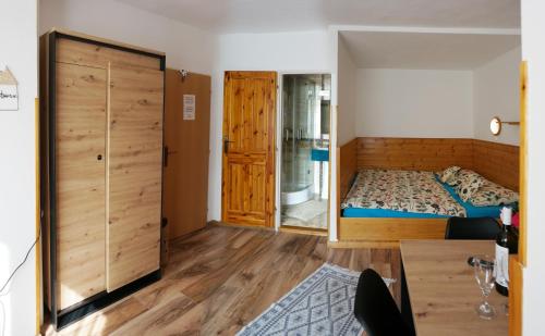 a bedroom with a bed and a wooden closet at Penzion a drevenica pri Hati in Terchová