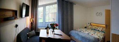 a bedroom with a bed and a table and a window at Penzion a drevenica pri Hati in Terchová