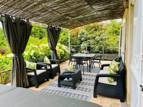 a patio with black chairs and a table and a table and chairs at Le Petit Usar in Loubens