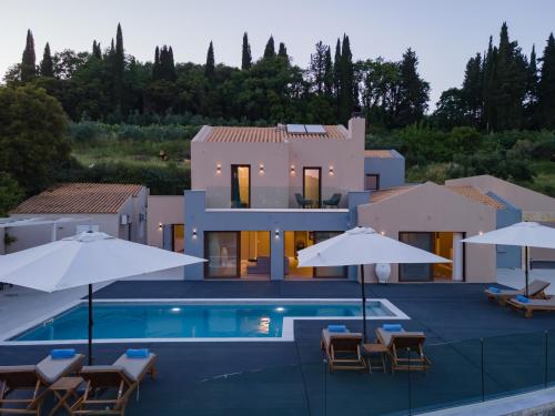 a villa with a swimming pool and umbrellas at Villa Athina Corfu - 4 bedrooms in Kynopiástai