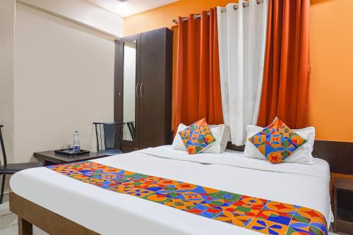 una camera con 2 letti e tende arancioni di FabHotel Royal Residency - Nr phoenix mall a Pune