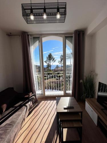 un salon avec une grande fenêtre avec vue dans l'établissement Cap Esterel, T2 pour 4 voyageurs, vue mer, parking et piscine, à Saint-Raphaël