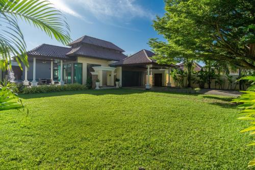 a house with a lawn in front of it at Ocean Palms Private Pool Villas in Ban Thalat Choeng Thale