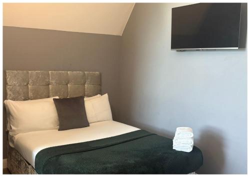 a bedroom with a bed with a flat screen tv on the wall at Hotel Anfield in Liverpool