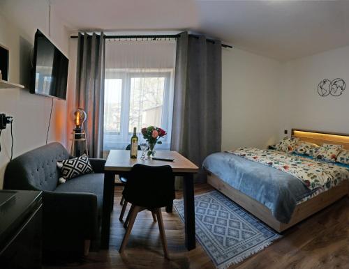 a bedroom with a bed and a table and a couch at Penzion a drevenica pri Hati in Terchová