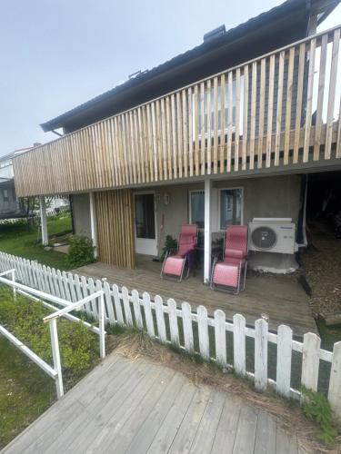 a porch with two chairs and a grill on a house at 3 roms 10 km fra Tromsø sentrum in Tromsø