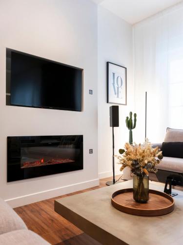 a living room with a fireplace with a tv above it at La Suite H in Metz