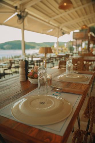 a wooden table with two plates and glasses on it at Ionion Beach Resort in Parga