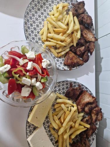 three plates of food with french fries and meat at I Love Koman Camping in Shkodër
