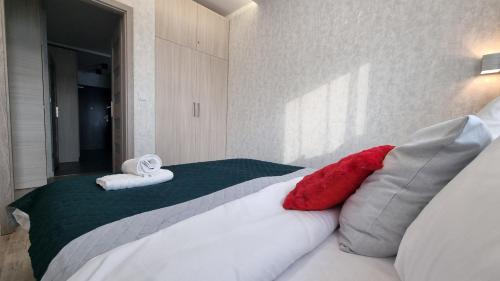 a bedroom with a bed with red and white pillows at Q Apart PL 2 lub 3 pokojowe klimatyzowane apartamenty przy Manufakturze z garażem Gratis, FV in Łódź