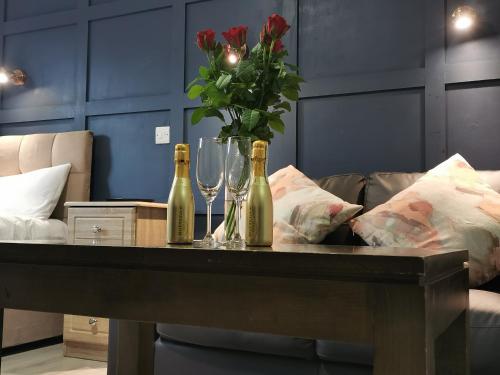 two champagne bottles and glasses on a table with a couch at N20 Inn Hotel in Mallow