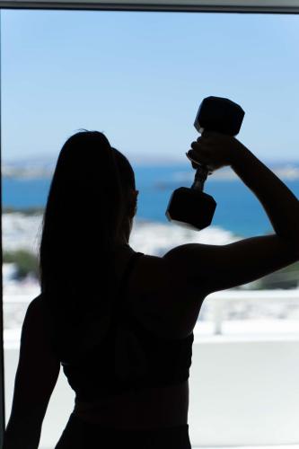 a woman holding a hair dryer in front of a window at Νumi Boutique Hotel in Mýkonos City