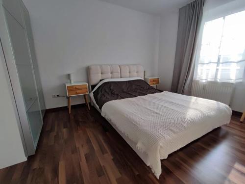a bedroom with a white bed and a wooden floor at Ferienwohnung Alte Mühle in Freital bei Dresden in Freital