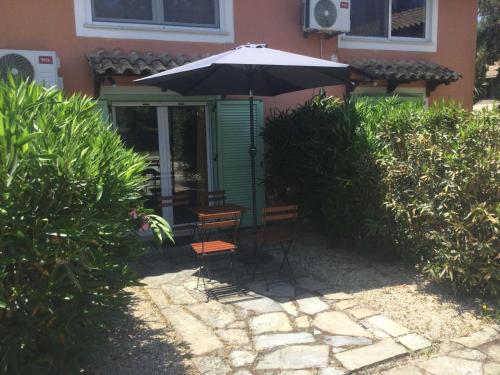 a table and chairs under an umbrella in front of a house at Harmony House Corfu 2 in Virós
