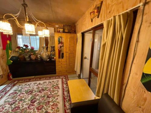 a living room with a table and a rug at AnNam Stay NEW HOTARUGAIKE in Toyonaka