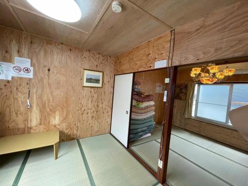 a room with wooden walls and a door and a window at AnNam Stay NEW HOTARUGAIKE in Toyonaka