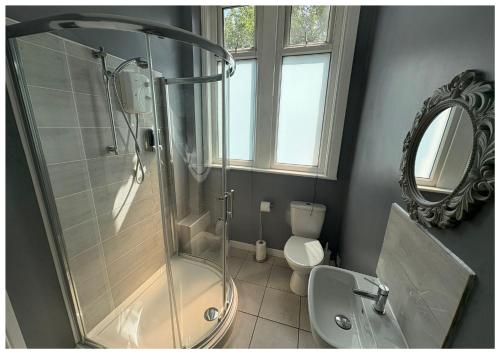 a bathroom with a shower and a toilet and a mirror at Hotel Anfield in Liverpool