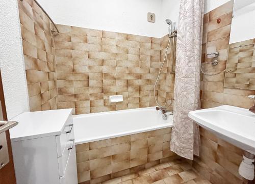 une salle de bain avec une baignoire et un lavabo dans l'établissement Appartement Vue Montagne à 500m des pistes, à Praz-sur-Arly