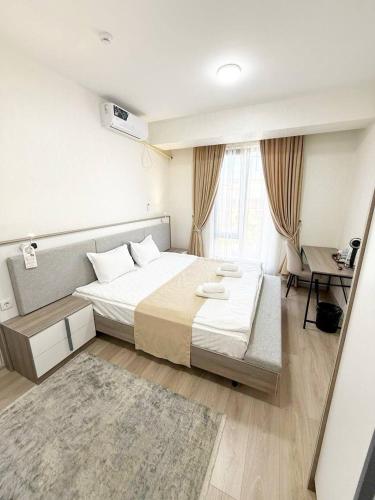 a bedroom with a large bed and a desk at SADI Hotel in Yakkasaray