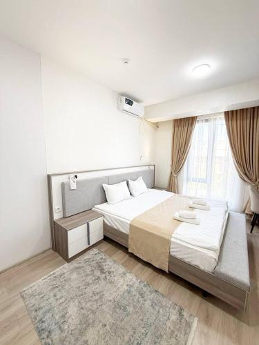 a bedroom with a large bed and a rug at SADI Hotel in Yakkasaray
