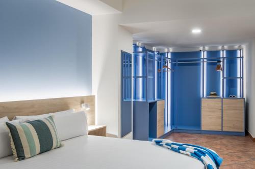 a bedroom with blue walls and a bed at ALEGRIA Colonial Mar Aquafun in Roquetas de Mar