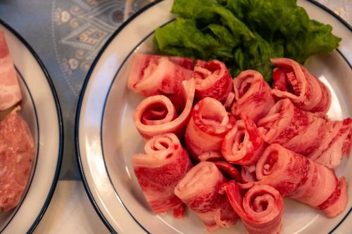 a plate of food with meat and lettuce on a table at Pension Balmy in Nasu