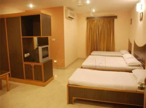 a hotel room with two beds and a tv at Vinttage park hotels in Bengaluru