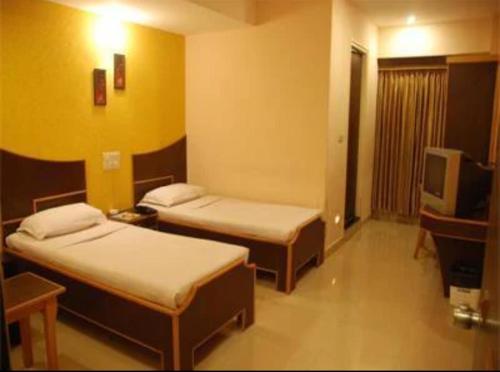 a hotel room with two beds and a television at Vinttage park hotels in Bengaluru