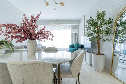 a dining room with a white table and chairs at Nasma Luxury Stays - Sky-High Serenity in Stylish 2BR Retreat in Dubai
