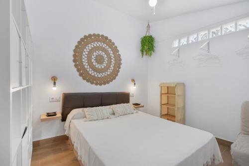 - une chambre avec un grand lit et des murs blancs dans l'établissement Melkart loft Sancti Petri, à Chiclana de la Frontera