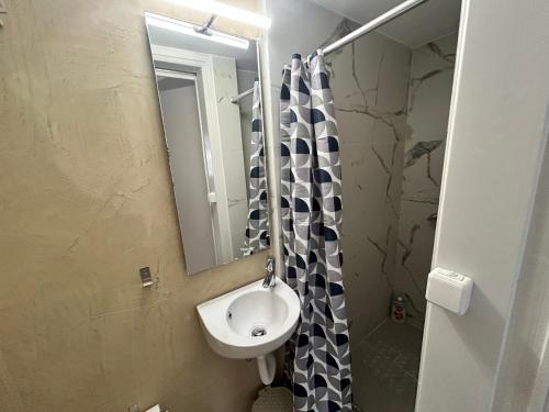 a small bathroom with a sink and a mirror at AKTIS apartment 1 near airport in Artemida