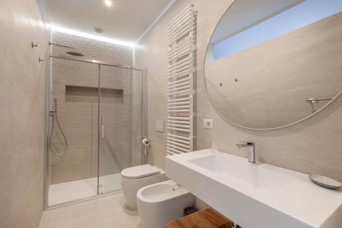 une salle de bains avec lavabo, toilettes et miroir dans l'établissement Vatican Suites, à Rome