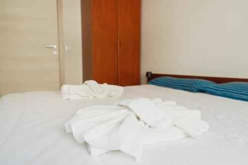 a bed with white towels on top of it at [Blu Kobler] - Ampio appartamento fronte mare in Lido di Jesolo