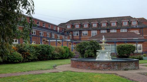a fountain in the middle of a yard with buildings at Best Western Thurrock Hotel in Grays Thurrock