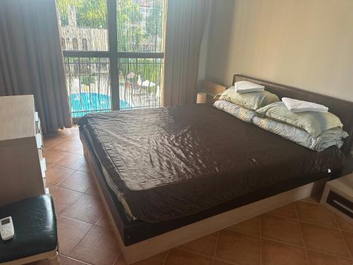 a bed in a bedroom with a view of a balcony at Kalia A7 Sunny Beach in Bŭnzareto