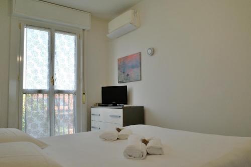 a white bedroom with two towels on a bed at BWR - Bilocale a Cornaredo ---vicino Rho Fiera--- in Cornaredo