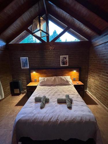 a bedroom with a large bed with two slippers on it at el cabure casa de campo in Esquel