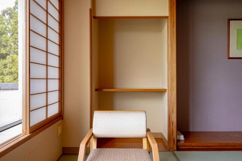 a chair sitting in a room next to a window at Rantei in Sendai