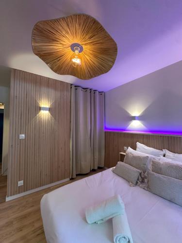 a bedroom with a large white bed with purple lighting at Studio MBS 2- Cosy, Tramway, Wifi, Parking, Equipé in Montpellier