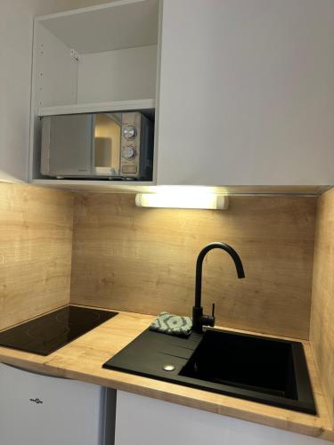a kitchen with a sink and a microwave at Studio MBS 2- Cosy, Tramway, Wifi, Parking, Equipé in Montpellier
