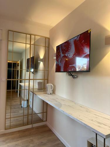 a room with a counter with a television on the wall at Studio MBS 2- Cosy, Tramway, Wifi, Parking, Equipé in Montpellier
