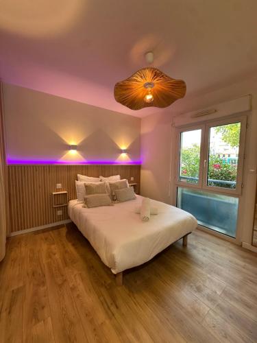 a bedroom with a large bed with purple lighting at Studio MBS 2- Cosy, Tramway, Wifi, Parking, Equipé in Montpellier