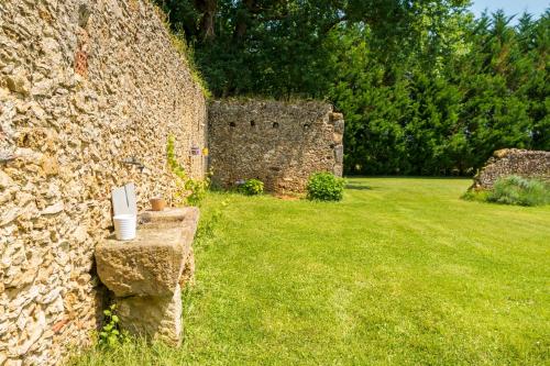 a stone wall with a chair in a yard at Chambre Balneo in Mauléon-dʼArmagnac