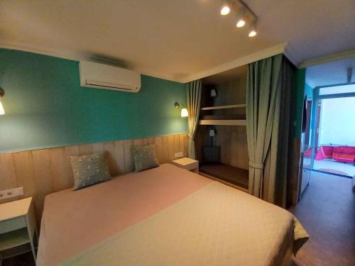 a bedroom with a white bed and a green wall at Studio in Balatonlelle 45323 in Balatonlelle