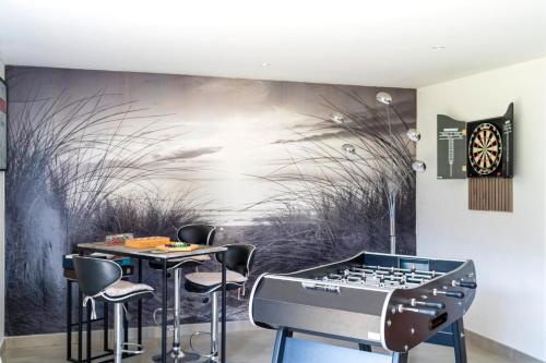 a dining room with a ping pong table and a wall mural at Chambre Balneo in Mauléon-dʼArmagnac