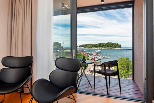 a room with a large window with a view of the water at Hotel Squero in Rovinj
