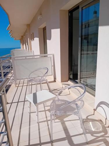 a patio with chairs and tables on a balcony at Hotel Miramare in Marina di Ragusa