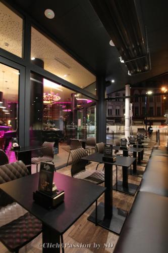 a restaurant with tables and chairs in a building at Hôtel de l'Univers Liège in Liège