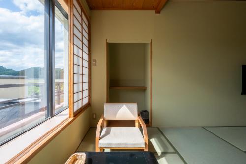 a room with a chair and a window at Rantei in Sendai